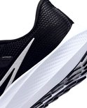 Detail van de zijkant van een zwarte Nike hardloopschoen, witte zool met textuur.