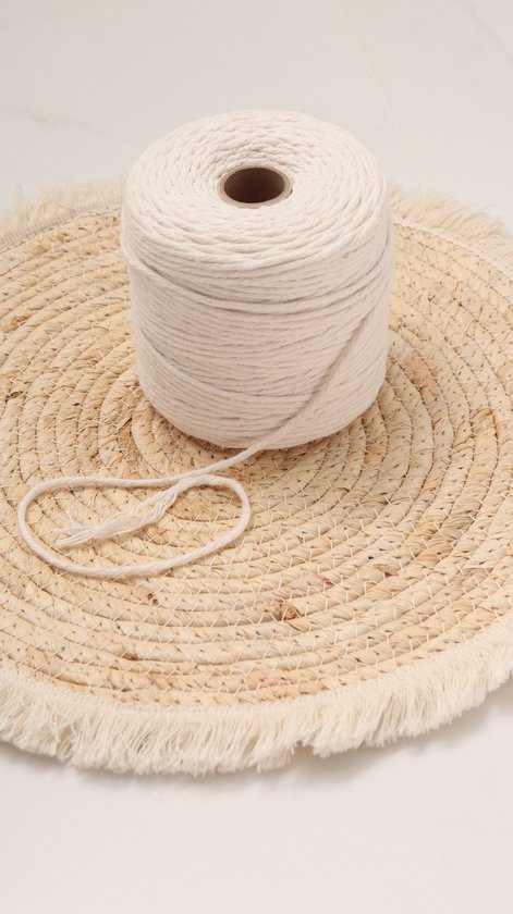 Rol naturel macramé koord op een rieten onderzetter met franjes.