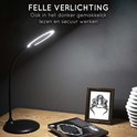 Lampe de bureau noire avec un éclairage LED lumineux sur un bureau à côté d'un livre.