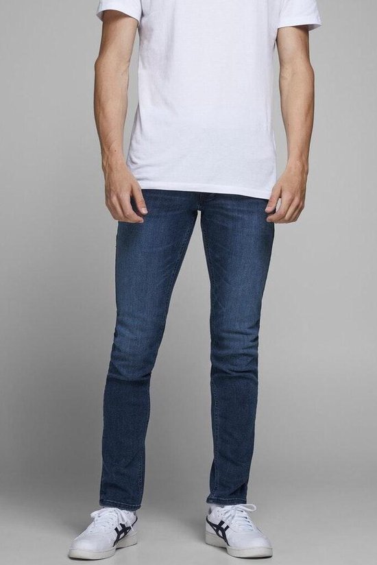 Man in spijkerbroek met een witte t-shirt.