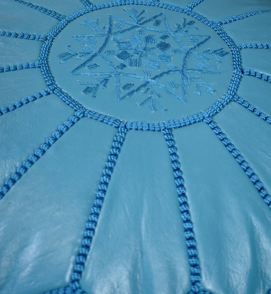 Turkooizen poef met geborduurde ster, omringd door decoratieve stiksels.