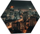 PVC Schuimplaat Hexagon - Stad - Gebouwen - Lichten - Avond - Donker - 50x43.5 cm Foto op Hexagon (Met Ophangsysteem)