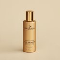 Gouden fles Face Tan Water van Eco Sonya Driver op beige achtergrond.