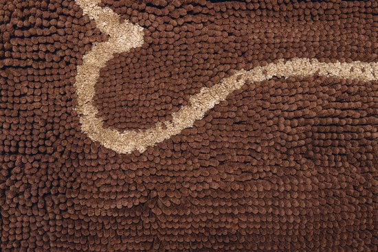 Detail van een bruine shaggy deurmat met een beige gebogen lijn.