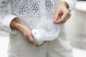 Vrouw houdt witte borstkolf met 26mm borstschildverkleiner vast. De verkleiner is doorzichtig.