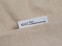 Label met tekst 100% linen produced in portugal op een beige linnen stof.