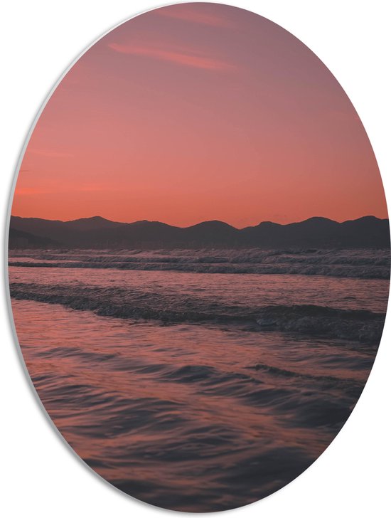 WallClassics - PVC Schuimplaat Ovaal - Golvende Zee met Oranje Paarse Lucht - 42x56 cm Foto op Ovaal (Met Ophangsysteem)