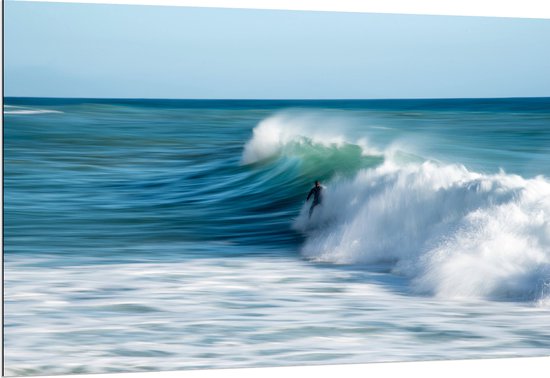 WallClassics - Dibond - Surfer over Razende Golven op Zee - 150x100 cm Foto op Aluminium (Wanddecoratie van metaal)