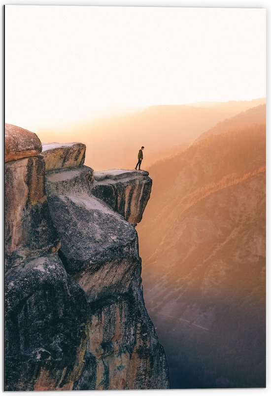 WallClassics - Dibond - Man aan de Rand van Hoge Cliff met Zonlicht - 70x105 cm Foto op Aluminium (Met Ophangsysteem)