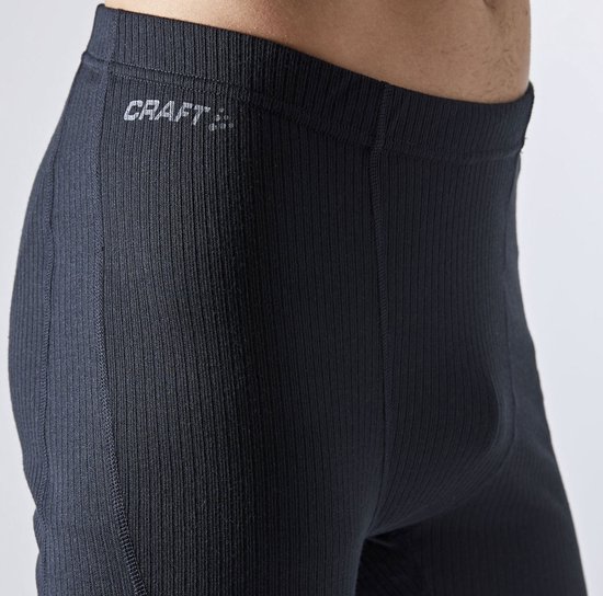 Detail van de zwarte, geribbelde tailleband van een thermolegging met Craft logo.
