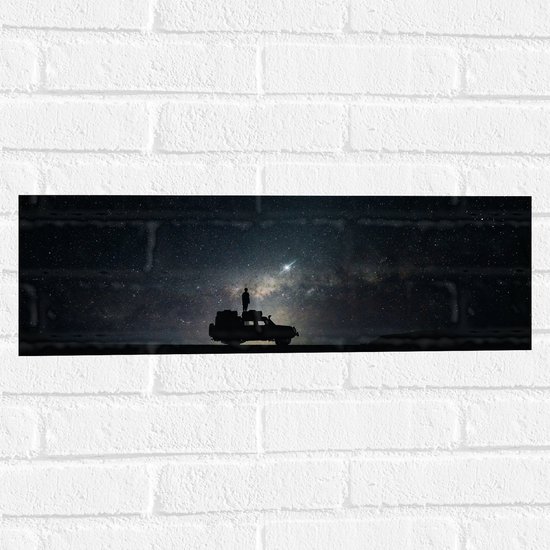 WallClassics - Muursticker - Persoon Staand op Auto onder Sterrenhemel - 60x20 cm Foto op Muursticker