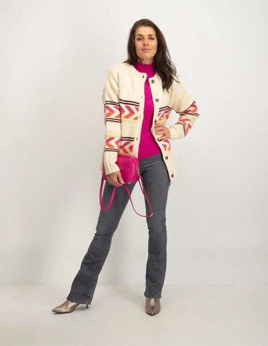 Model met grijze flared jeans, gebreid vest en roze tasje.
