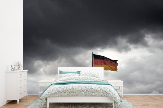 Papier peint vinyle - Drapeau allemand à Berlin contre les nuages sombres largeur 600 cm x hauteur 400 cm - Tirage photo sur papier peint (disponible en 7 tailles)
