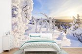 Behang - Fotobehang De zon schijnt op een besneeuwd winterlandschap - Breedte 360 cm x hoogte 240 cm