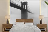 Behang - Fotobehang Mist bedekt de Brooklyn Brug in New York in zwart-wit - Breedte 260 cm x hoogte 260 cm