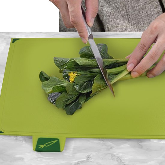 Groene snijplank met een bosje groenten en een mes.