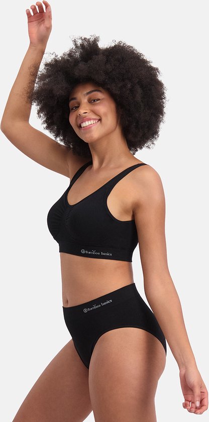 Model met krullend haar draagt een zwarte naadloze bralette en slip met "Bamboo Basics" logo.