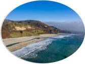 PVC Schuimplaat Ovaal - Oceaan Aanstromend bij Strand aan Rand van de Berg - 68x51 cm Foto op Ovaal (Met Ophangsysteem)