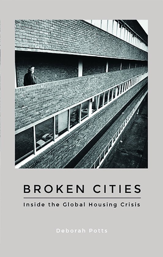 Boekomslag: zwart-witfoto van een bakstenen appartementsgebouw met tekst 'Broken Cities: Inside the Global Housing Crisis'.