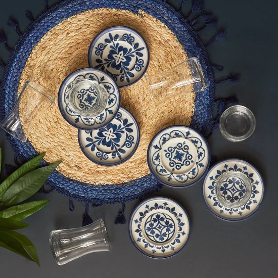 Un ensemble de six soucoupes à motifs bleus et six verres, disposés sur une set de table ronde.