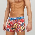 Koraalrode boxershorts met tropische print van bloemen en bladeren. Blauwe band met 'JACK & JONES' logo, gedragen door een man.