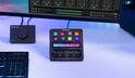 Zwart Stream Deck+ met 8 toetsen, LCD-scherm en 4 draaiknoppen op een bureau naast een toetsenbord.
