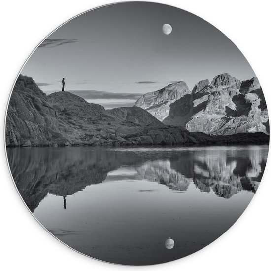WallClassics - PVC Schuimplaat Muurcirkel - Persoon op Rotsen langs Water met Maan in zwart-wit - 70x70 cm Foto op Muurcirkel (met ophangsysteem)