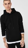Man met tatoeages draagt een zwarte hoodie met capuchon en kangoeroezak.