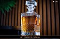 Een kristallen whiskykaraf gevuld met amberkleurige drank, op een donkere achtergrond met de tekst 'Het Perfecte Cadeau'.