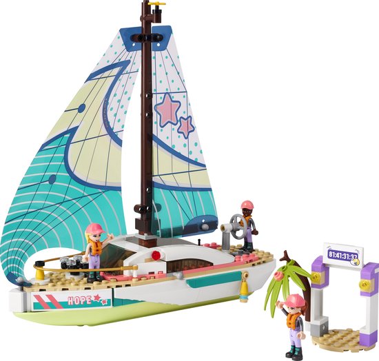LEGO Friends zeilboot met drie poppetjes, met een racepoort en palmboom ernaast.