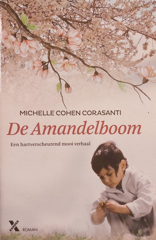 Jongetje in wit gewaad zit in het gras en bekijkt een bloem. Boven hem hangt een tak met bloeiende bloesems.