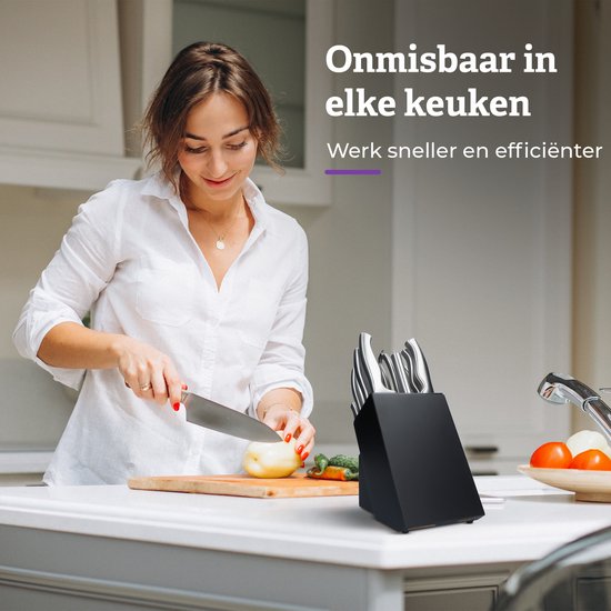 Vrouw in witte blouse snijdt ui in keuken, met een messenblok op het aanrecht.