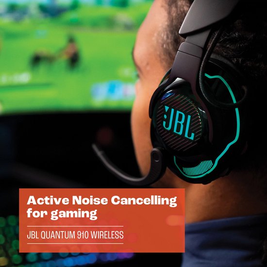 Man met een JBL Quantum 910 WIRELESS headset met blauwe accenten, kijkt naar een gaming monitor.