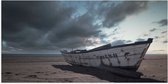WallClassics - Poster Glanzend – Witte Boot op het Strand onder Donkere Wolken - 100x50 cm Foto op Posterpapier met Glanzende Afwerking