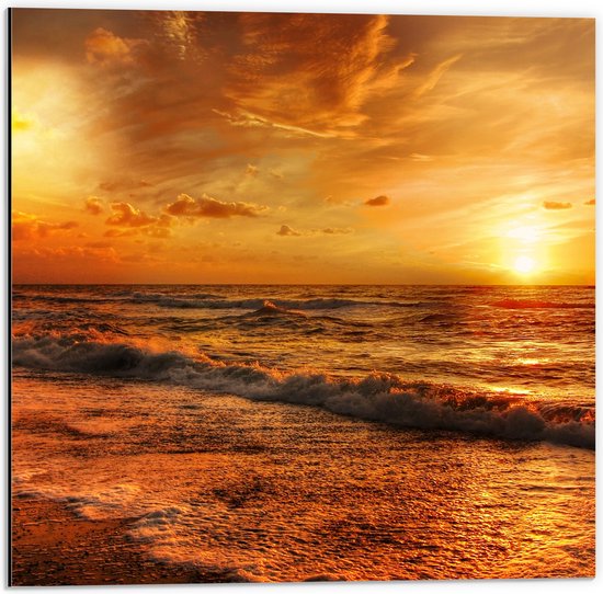 Coucher de soleil doré sur l'océan, vagues s'écrasant sur la plage, nuages dramatiques.