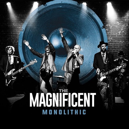 Live band The Magnificent Monolithic met zanger, gitarist, bassist en drummer voor een grote blauwe luidspreker.
