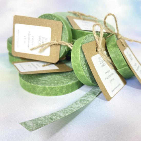 Groene klittenbandrollen met bruine labels, één stukje lint is los.
