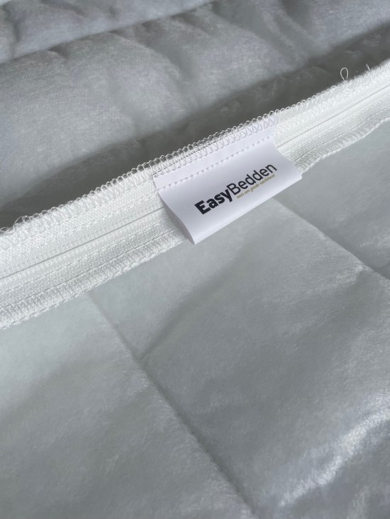 Wit gestikt matras met een open ritssluiting en een EasyBedden label.