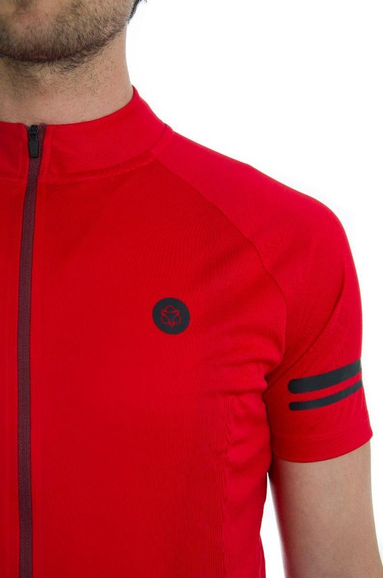 Detail van een rood fietsshirt met zwarte rits, zilveren logo op de borst en zilveren strepen op de mouw.