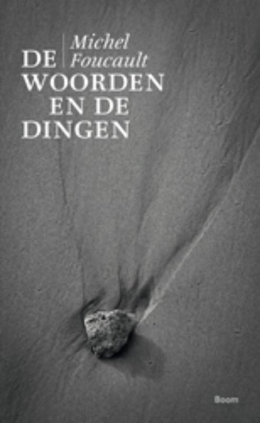 Boekcover van 'De woorden en de dingen' door Michel Foucault. Zwart-wit foto van zand met een steen erop. Tekst 'Michel Foucault De Woorden EN DE Dingen' bovenaan.