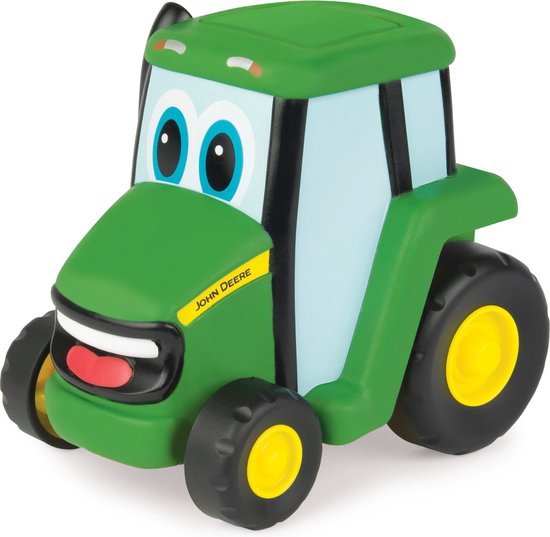 Groene John Deere speelgoed tractor met blauwe ogen, een rode mond en gele velgen op de wielen.