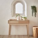 Houten consoletafel met twee laden, gedecoreerd met vazen en planten, naast een ronde houten kruk.