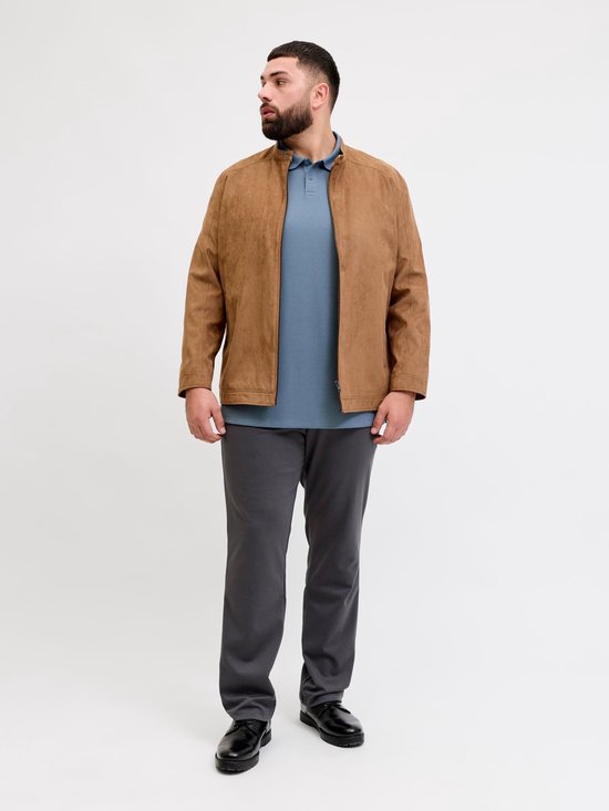 Man met baard in blauw poloshirt en bruine suède jas.