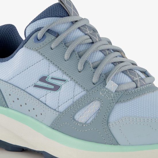 Detail van de veters en het S-logo op een blauwe Skechers sneaker met mintgroene accenten.
