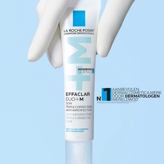 Des gants gris tiennent un tube La Roche-Posay Effaclar Duo+M.