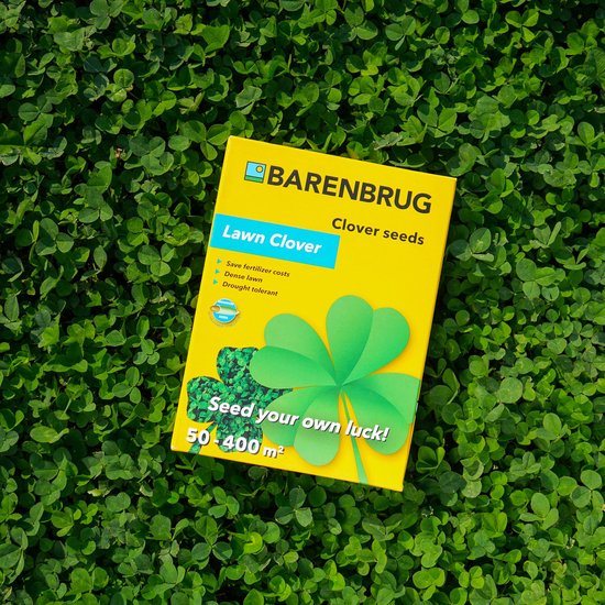 Gele Barenbrug Lawn Clover verpakking met groene klaver en tekst, liggend op een bed van groene klaverblaadjes.