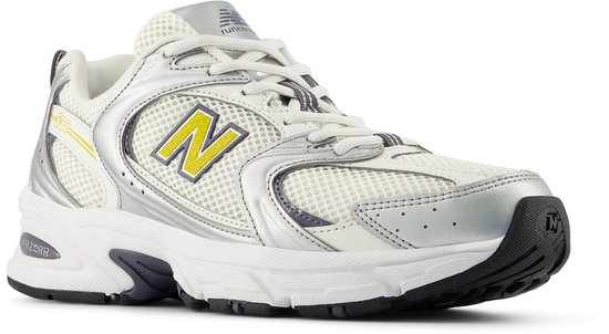 Basket New Balance blanche avec accents argentés, logo 'N' jaune et inscription '530'.