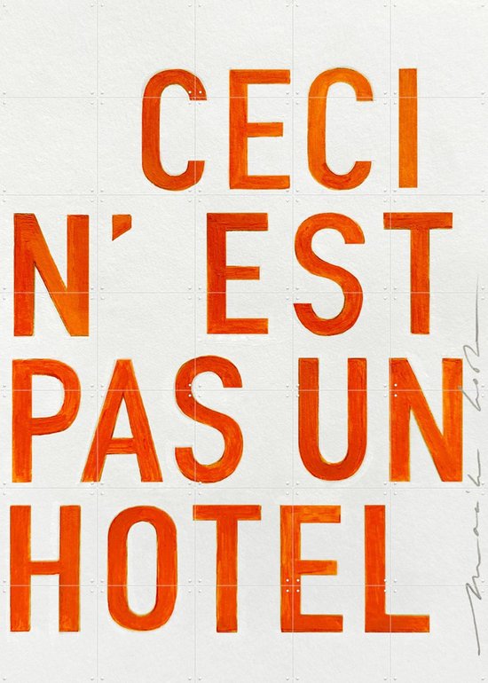 Texte 'CECI N'EST PAS UN HOTEL' en lettres oranges, photographié de près.