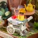 Miniatuur karretje met gebak, aardbeien, koekjes en een Rolife-vlaggetje.