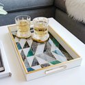 Wit dienblad met geometrisch marmerpatroon in groen, grijs en wit, met gouden rand. Met twee glazen drankjes.